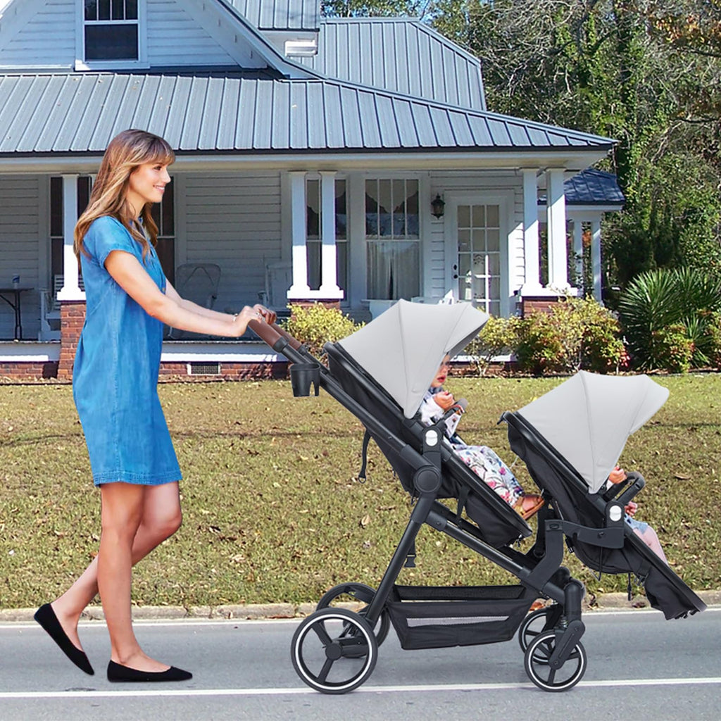 Dark grey tandem double stroller for newborn and toddler twins with reversible seats, adjustable canopy, 5-point harness, and large storage.